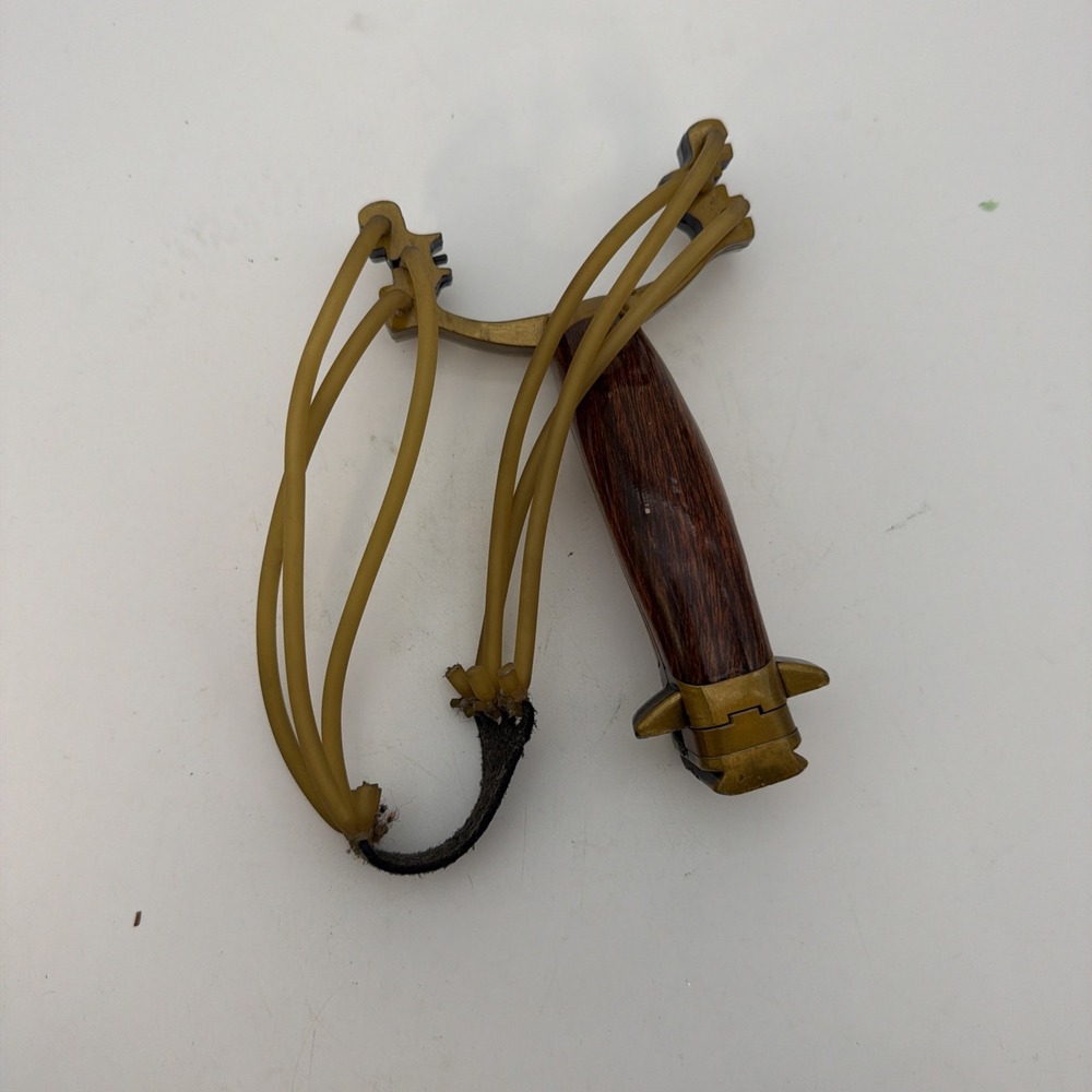 metal and plastic slingshot with a wood-effect handle and yellow rubber bands
